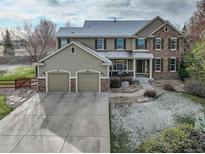 Inviting two-story home featuring a stone and siding exterior with a two car garage at 4810 Mountain Gold Run, Broomfield, CO 80023