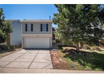 Charming two-story home featuring a two-car garage and well-maintained front yard and steps to the entry at 19876 E Brunswick Dr, Aurora, CO 80013