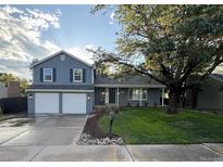 Charming two-story home featuring a two-car garage, a well-maintained lawn, and mature trees at 7163 S Xanthia St, Centennial, CO 80112