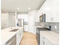 Modern kitchen with stainless steel appliances and white cabinets at 8905 Rifle St, Commerce City, CO 80022