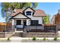 Charming two-story home with black trim, well-maintained lawn, and a cozy, fenced front patio at 1484 Cherry St, Denver, CO 80220