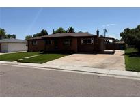 Charming single-story home with brick and wood siding, well-manicured lawn, and covered parking at 3334 W Grand Ave, Englewood, CO 80110