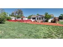 Charming home featuring a well-maintained lawn, cozy red patio, and easy-to-care landscaping at 2401 W Jewell Ave, Denver, CO 80219