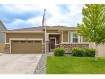 Ranch home with a two-car garage, stone accents, neutral paint, well-kept lawn and an American flag at 3936 Costillo Ct, Brighton, CO 80601