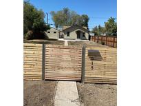Charming home featuring a modern horizontal wood fence with metal accents and visible street address at 915 N Irving St, Denver, CO 80204