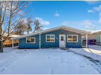 Ranch style home with blue siding, snowy yard, and visible address number at 1341 Sharpe Pl, Longmont, CO 80501