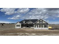 Charming single-story home featuring stone accents, gray siding, dark shutters, and a covered front porch at 270 High Meadows Loop, Elizabeth, CO 80107