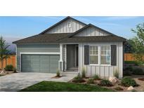 Charming single-story home with gray siding, a two-car garage, landscaped yard and inviting covered entrance at 1548 Orchard St, Brighton, CO 80601