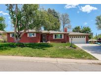 Charming brick ranch-style home with a well-manicured lawn and a two-car attached garage at 3090 S High St, Denver, CO 80210
