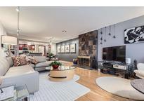 Spacious living room with a fireplace and hardwood floors leading into an open kitchen layout at 800 N Pearl St # 206, Denver, CO 80203