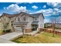 Charming two-story home with attached garage, stone accents, manicured lawn and wood fence at 4808 S Picadilly Ct, Aurora, CO 80015