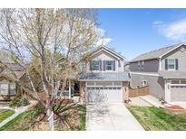 Charming two-story home with a well-manicured lawn and a covered front porch at 1169 Thornbury Pl, Highlands Ranch, CO 80129