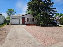 Charming single-story home featuring a red front door, gravel landscaping, and a mature shade tree at 1233 Lansing St, Aurora, CO 80010