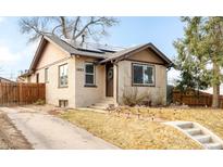 Charming brick home with a well-maintained yard and solar panels on the roof at 1453 Rosemary St, Denver, CO 80220