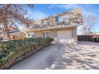 Charming home featuring a well-maintained lawn, a driveway, and an attached garage, perfect for suburban living at 5011 Troy St, Denver, CO 80239
