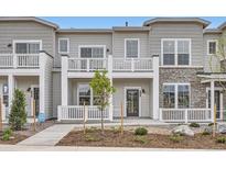 Inviting townhouse featuring a private balcony, a well-manicured lawn, and a charming, light gray exterior at 8895 San Antonio St, Littleton, CO 80125