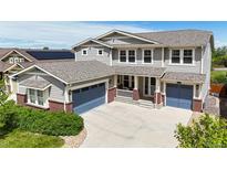 Charming two-story home featuring a well-manicured lawn, a welcoming porch, and a two-car garage, ideal for a growing Gathering at 5932 Eldora St, Golden, CO 80403