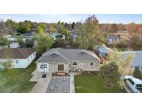 Aerial view of a charming stone-clad home with mature trees and a basketball hoop in the driveway at 1085 Victor St, Aurora, CO 80011