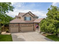 Charming two-story home featuring a brick facade, three-car garage, tile roof, and an inviting front porch with American flag at 13753 Monroe St, Thornton, CO 80602