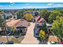 Charming residential neighborhood featuring well-maintained homes, mature trees, and a glimpse of the city skyline in the background at 2736 W 24Th Ave, Denver, CO 80211