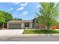 Charming split-level home featuring a well-maintained front yard and attached two-car garage at 10926 Dahlia Way, Thornton, CO 80233