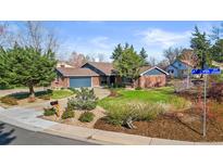 Charming brick home featuring a two car garage, mature trees, and a lush front yard at 10801 W 29Th Ave, Lakewood, CO 80215