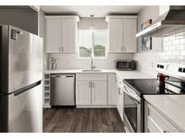 Bright kitchen features stainless steel appliances, white cabinets, subway tile backsplash and sleek countertop at 2271 Coronado N Pkwy # D, Denver, CO 80229