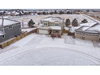 Beautiful two-story home with attached garage in a snowy neighborhood at 1523 Honeysuckle Ct, Brighton, CO 80601