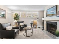Living room featuring a brick fireplace, large window, neutral paint and carpet at 9110 E Girard Ave # 1, Denver, CO 80231