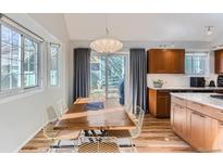 Bright dining room with wood table, modern lighting, and sliding door to the back yard at 4861 Curie Ct, Boulder, CO 80301