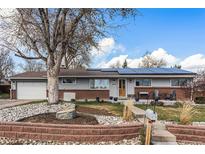 Charming ranch-style home with brick accents, solar panels, a well-kept yard, and mature landscaping at 6719 W 70Th Ave, Arvada, CO 80003