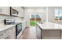 Modern kitchen with stainless steel appliances, a center island, and quartz countertops for a sleek and functional cooking space at 1399 Orchard St, Brighton, CO 80601