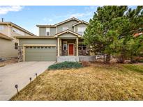 Charming two-story home with a well-manicured lawn, stone accents, and an attached two car garage at 23662 E Alabama Dr, Aurora, CO 80018