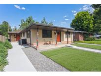 Charming home with a well-maintained front yard and cozy porch seating at 1112-1112 1/2 Krameria St, Denver, CO 80220