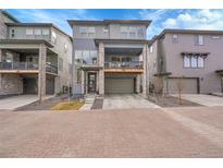 Modern three-story home with a stone accent facade, balcony, and two-car garage at 15794 W Girard Ave, Morrison, CO 80465
