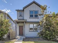 Charming home featuring modern architecture and appealing gray siding, set against a bright blue sky at 4773 Kittredge St, Denver, CO 80239