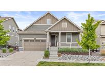 Charming home featuring a landscaped front yard, covered porch, and attached two-car garage at 757 Cabot Dr, Erie, CO 80516