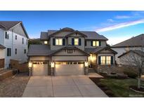 Charming two-story home featuring a three-car garage, stone accents, and a welcoming front entrance at 10969 Valleybrook Cir, Highlands Ranch, CO 80130