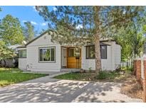 Charming single-Gathering home featuring a wood accent front door, landscaped yard, and a concrete driveway at 1732 Lansing St, Aurora, CO 80010