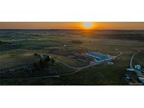 Expansive aerial view of horse property with riding arena at sunset at 27115 County Road 13, Elizabeth, CO 80107