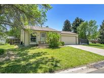 Charming ranch-style home featuring a well-maintained lawn, mature trees, and an attached two-car garage at 8848 Prickly Pear Cir, Parker, CO 80134