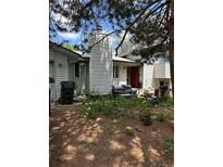 Overgrown front yard featuring a white house with a red door and discarded furniture at 3150 W 134Th Ave, Broomfield, CO 80020