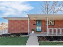 Charming brick home featuring a cozy covered porch and walkway leading to the front door at 1476 W Dakota Ave, Denver, CO 80223