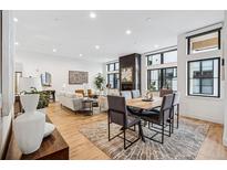 Spacious open-concept living room with fireplace, dining area, and large windows, filled with natural light at 838 Ash St # 1, Denver, CO 80220