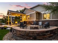 Outdoor patio featuring a fire pit, seating area, and covered porch perfect for entertaining or relaxing in the evening at 3107 S Nepal Way, Aurora, CO 80013