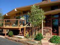 Charming home featuring a stone facade, inviting deck, and beautiful landscaping at 107 Elk Dr, Evergreen, CO 80439