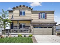 Inviting two-story home featuring a covered porch, attached two-car garage, and well-maintained front lawn at 5336 Trails Edge Ln, Castle Rock, CO 80104