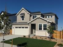 Charming two-story home featuring a well-manicured lawn, a two-car garage, and a welcoming facade at 9374 Quartz St, Arvada, CO 80007