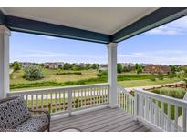 Relaxing back porch with seating and view of open green space and neighboring houses at 10387 Harrisburg St, Parker, CO 80134