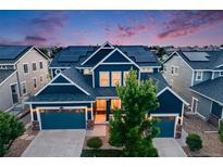 Beautiful two-story navy blue home showcasing a three-car garage and solar panels at 10387 Harrisburg St, Parker, CO 80134